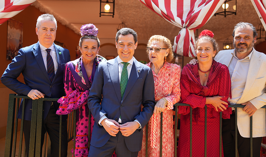 El presidente de la Junta de Andalucía, junto a varios acompañantes, delante de una caseta.